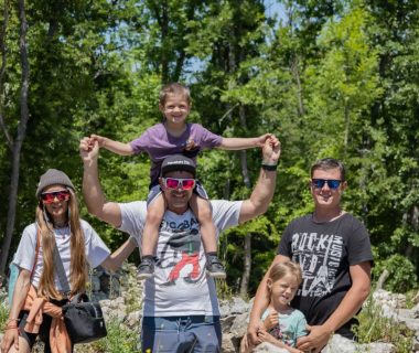 A joyful family enjoying a sunny day outdoors, captured in a lively and happy moment.